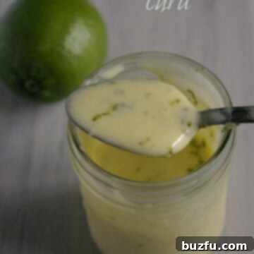 Freshly made lime curd, vibrant yellow and smooth, in a glass jar.