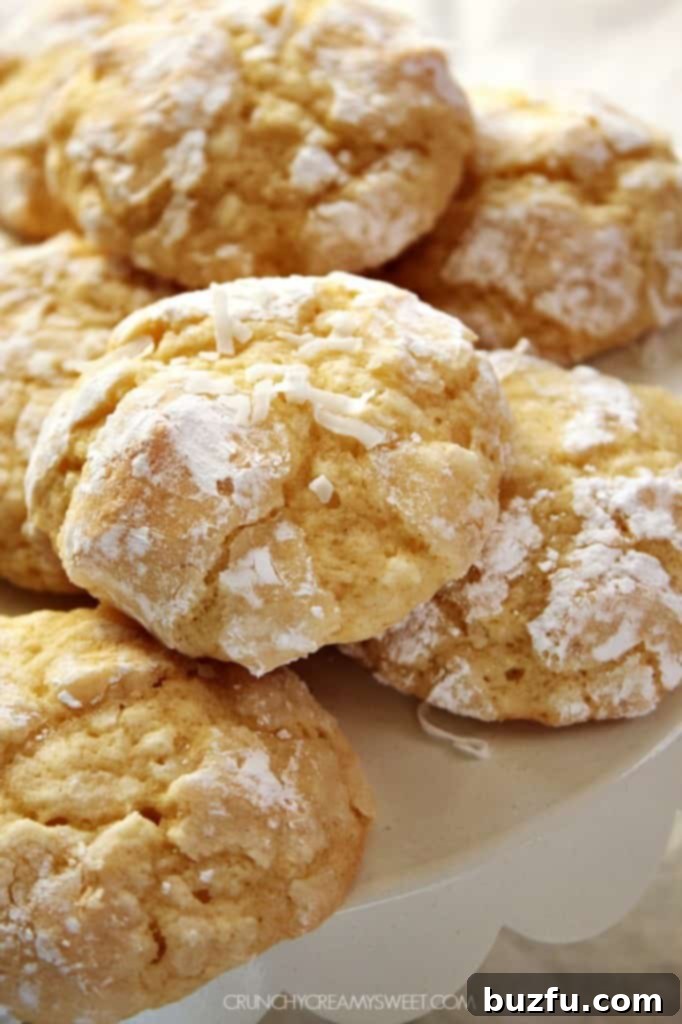 Close-up of a Coconut Crinkle Cookie, highlighting its sugary, cracked surface and soft texture.