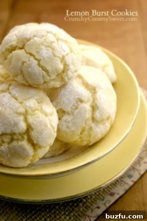 A stack of golden Lemon Burst Cookies with a light dusting of powdered sugar.