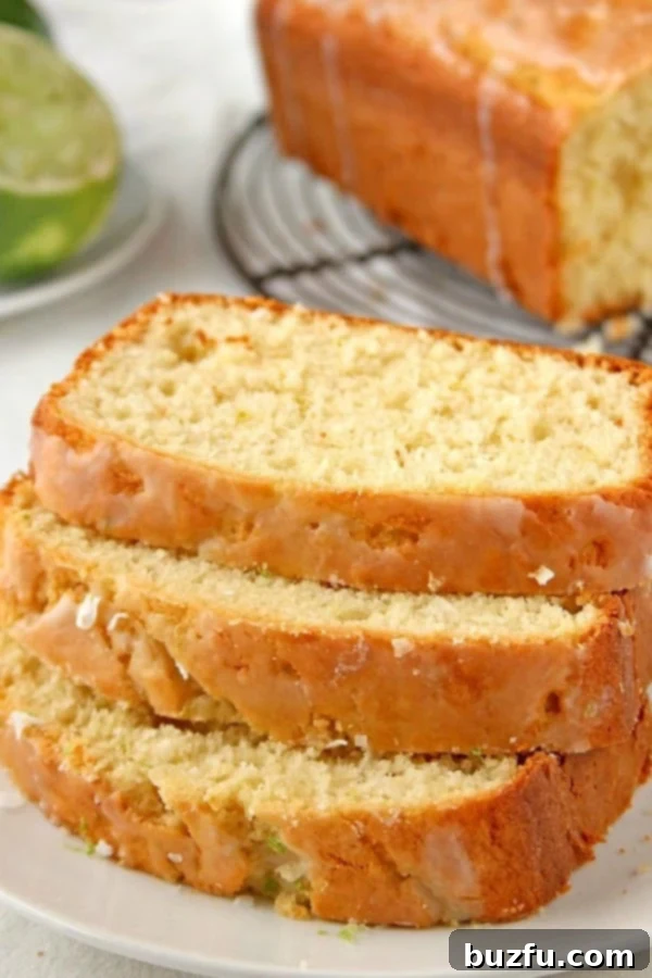 Glazed Lemon Coconut Loaf cake sliced on plate, revealing its soft interior.