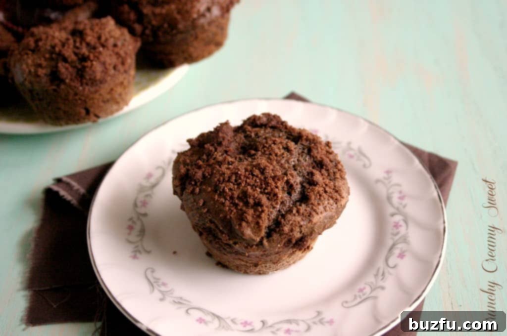 Cocoa Muffins with Streusel Two cocoa muffins with a rich, crumbly streusel topping, sitting on a baking sheet, glistening with potential.