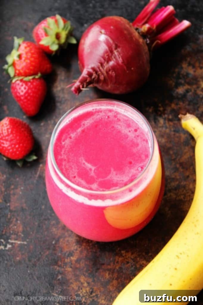 Beets and Berries Smoothie - a power-drink that's packed with Vitamins, anti-oxidants and gives your skin a healthy glow. #recipe #healthy #smoothie crunchycreamysweet.com Vibrant Beet Smoothie served in a glass, ready to drink.