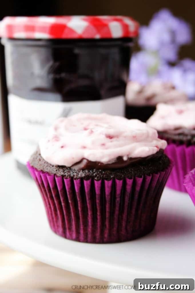 Close-up of a beautifully frosted Chocolate Cherry Cupcake, showcasing the fluffy cream and ganache layers, ready to be enjoyed.