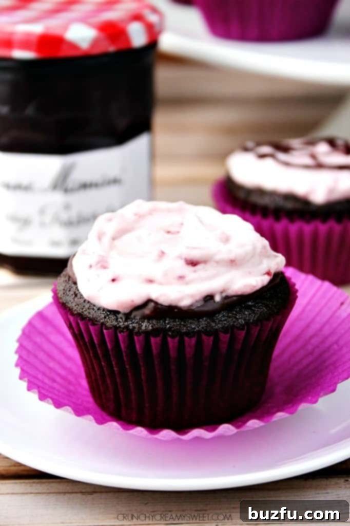 Chocolate Cupcakes adorned with a light and fluffy Cherry Cream Topping, artfully swirled and ready to be served.