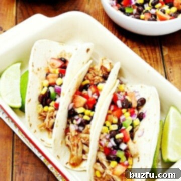 Three chicken tacos in a baking dish, ready to serve.
