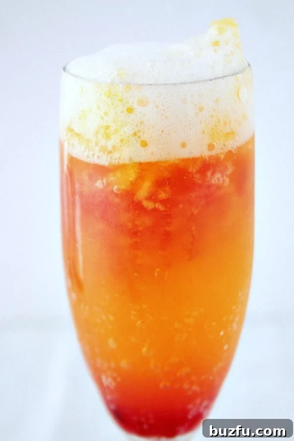 Cranberry Orange Mimosa in tall glass.