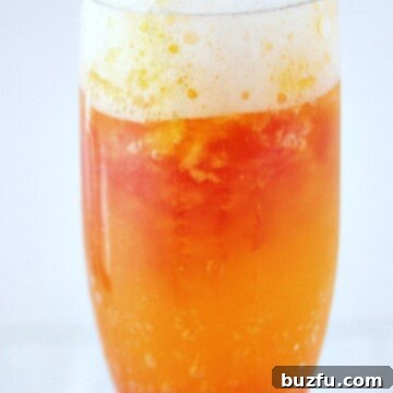 Cranberry Orange Mimosa in tall glass.