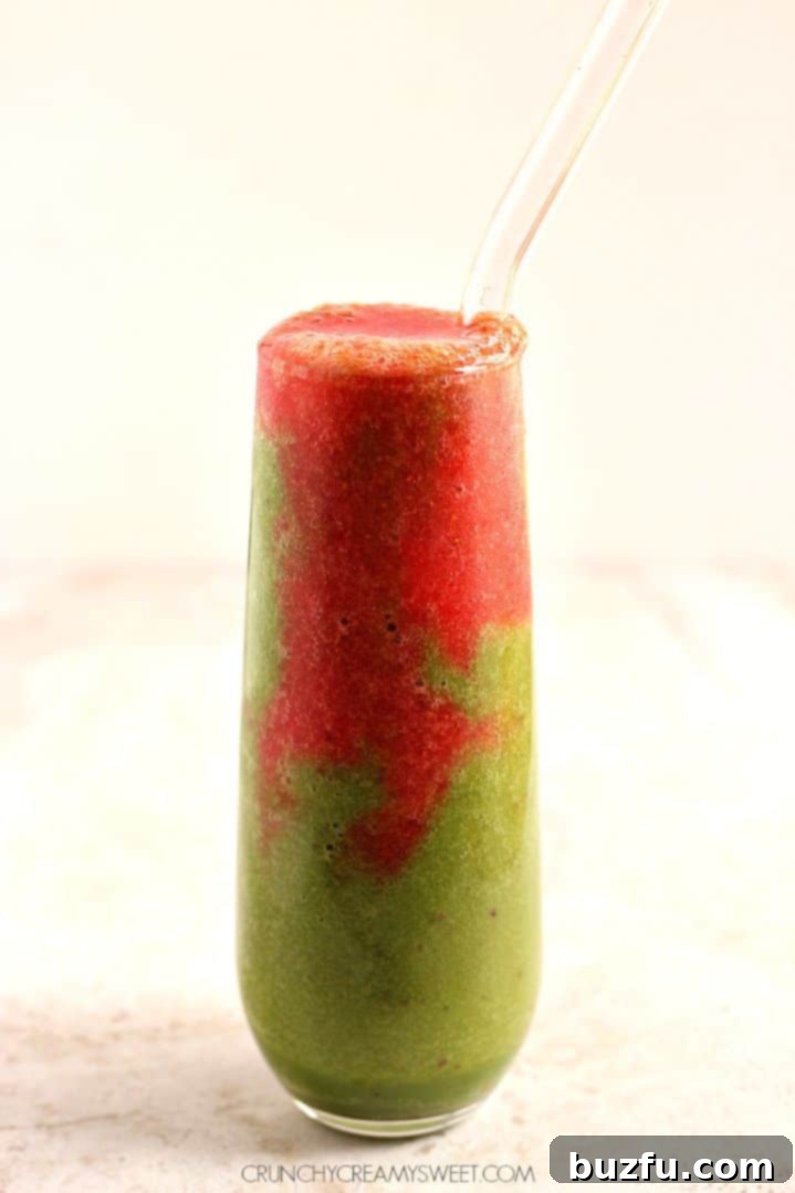 Enjoying a fun and healthy Lava Flow Green Smoothie Close-up of Lava Flow Green Smoothie showing the red strawberry layer flowing into the green base