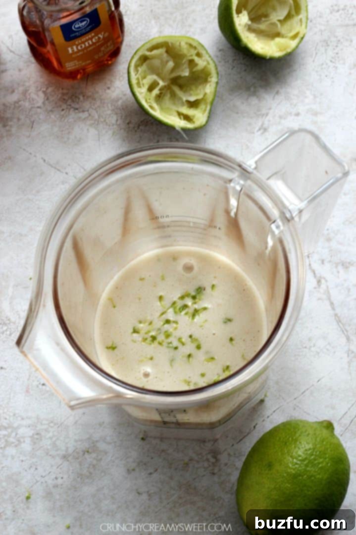 Lime and lime zest in blender jar.