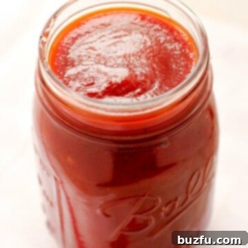 Side shot of BBQ sauce in a glass jar.