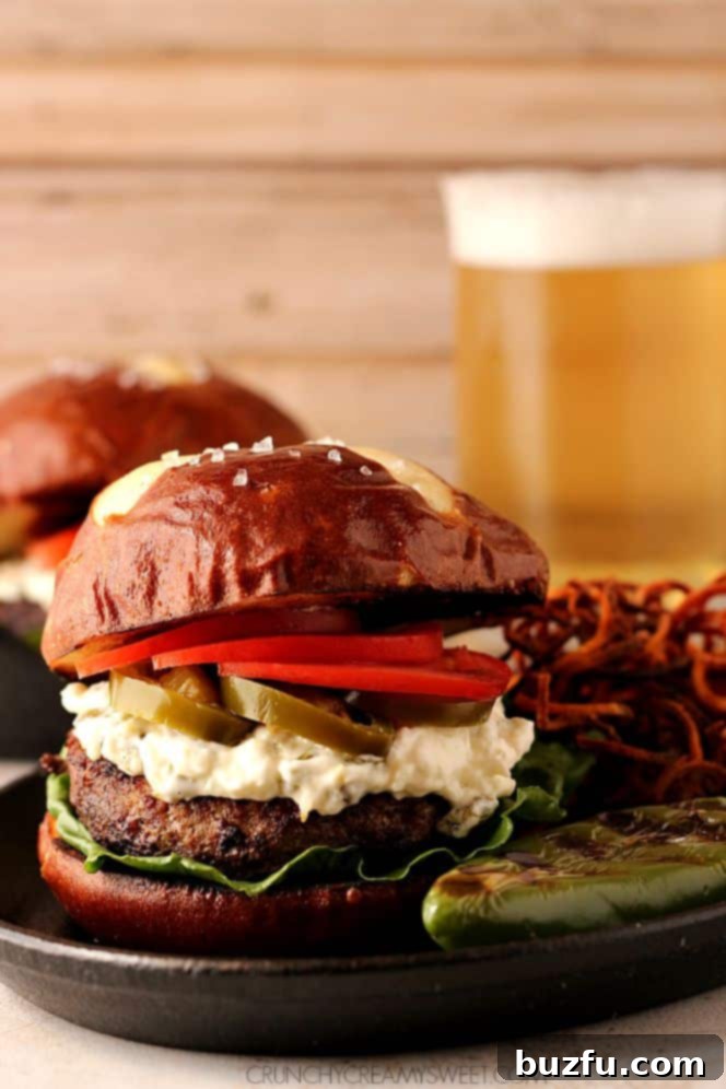 Delectable Jalapeno Popper Burger with creamy filling Close-up of a Jalapeno Popper Burger, showing the creamy filling and a crispy pretzel bun