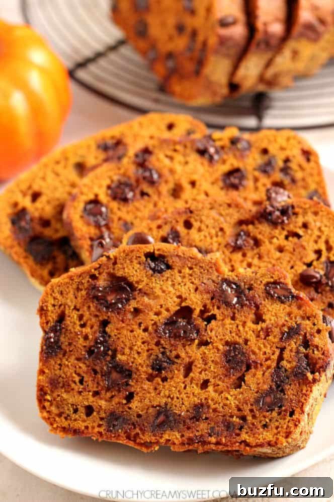 Sliced pumpkin chocolate chip bread on a cutting board, showing the chocolate chips.