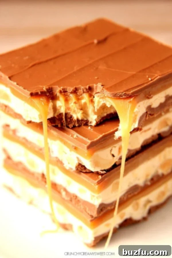 Homemade Snickers bars stacked invitingly on top of each other, showcasing their rich layers of chocolate, nougat, and caramel.