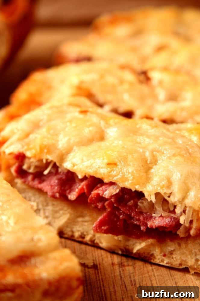 Easy Reuben Cheesy Bread: Classic Reuben flavors on toasted Italian bread for an unforgettable appetizer or meal. Easy Reuben Cheesy Bread with melted Swiss cheese, corned beef, and sauerkraut on a cutting board, ready to serve.