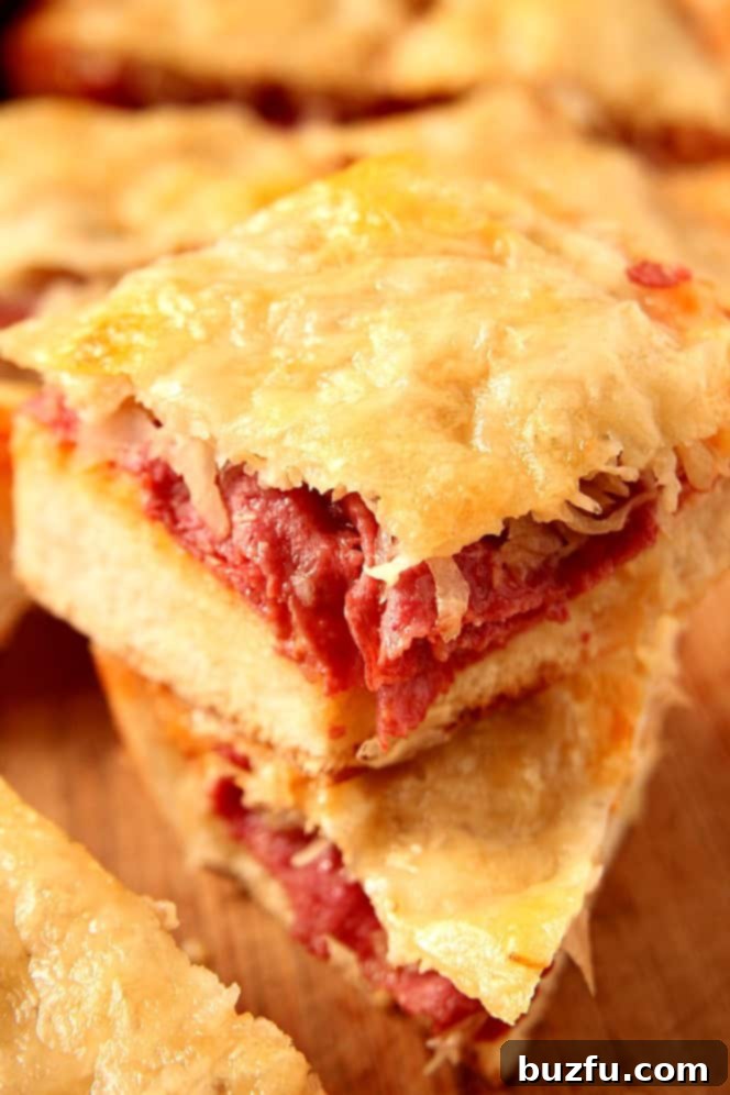Addictive Reuben Cheesy Bread slice, showcasing gooey Swiss cheese and savory ingredients. Close-up of a slice of Easy Reuben Cheesy Bread being pulled away, showing the melted Swiss cheese and rich fillings.