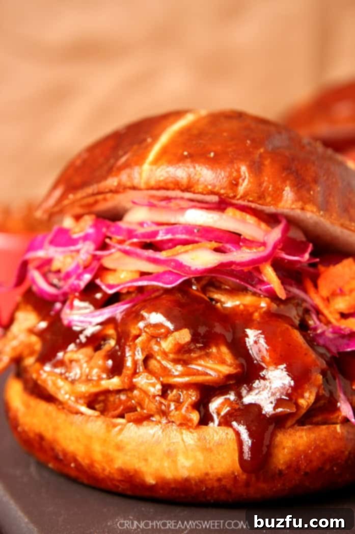 Slow Cooker Pulled Pork in a pretzel bun with coleslaw, ready to be served as a delicious meal.