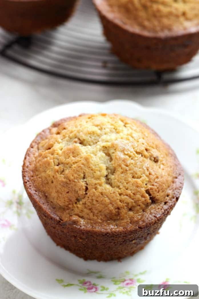 Cinnamon Swirl Peanut Butter Banana Muffins - soft and fluffy banana muffins with a surprise cinnamon swirl and peanut butter chips. Cinnamon Swirl Peanut Butter Banana Muffins cooling on a rack, with one cut open to reveal the swirl.
