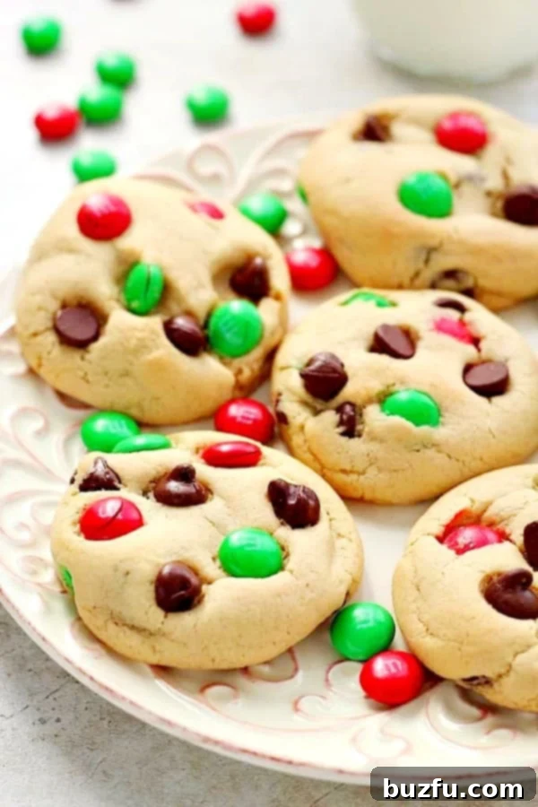 How to make the best Christmas M&M Cookies for a joyful holiday! Christmas M&M Cookies on plate with scattered red and green candy, highlighting the colorful additions.