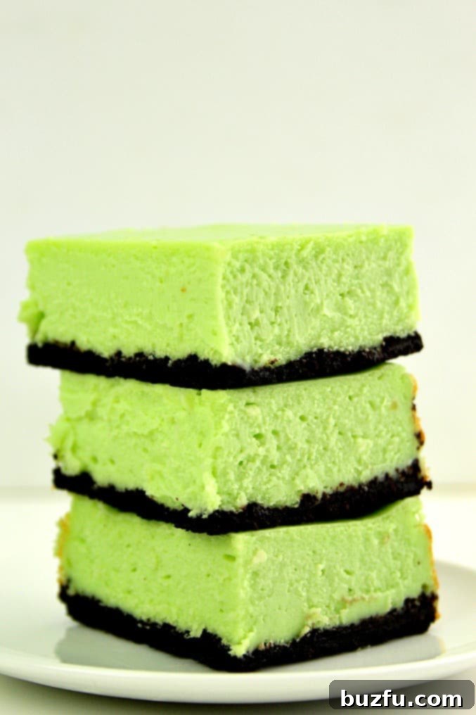 Several Mint Cheesecake Bars arranged on a serving plate, highlighting their perfect squares and inviting green color.