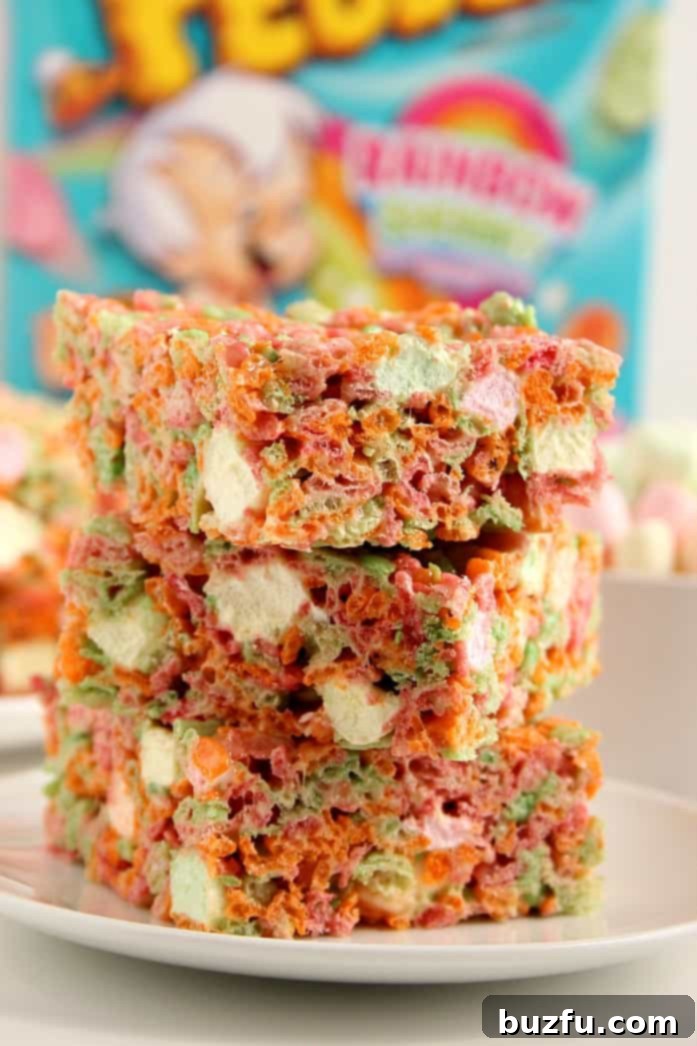 A stack of perfectly cut Ice Cream Pebbles Marshmallow Cereal Bars, showing their thickness and vibrant layers.