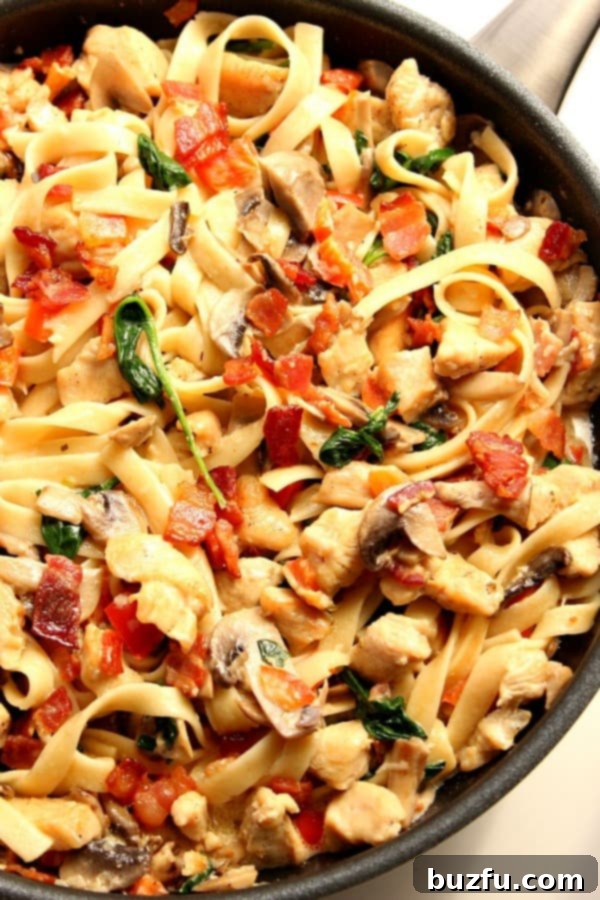 Creamy Mushroom Chicken Pasta with bacon in skillet.