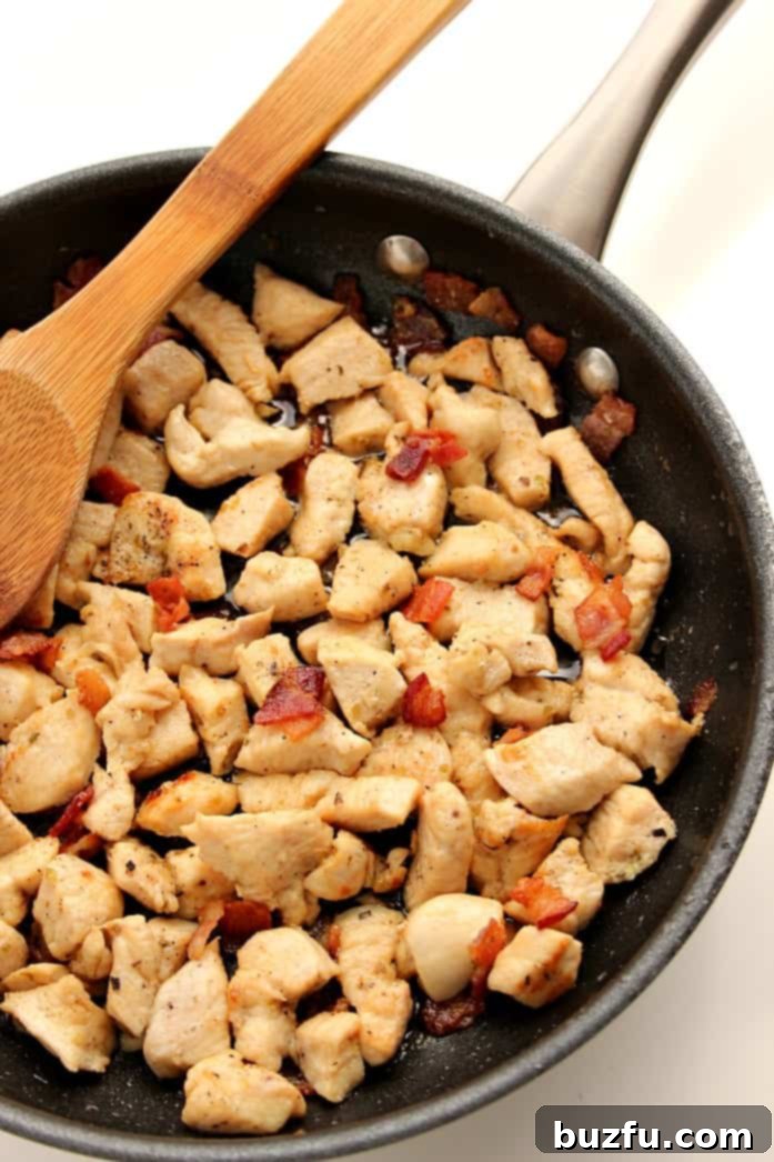 Cooked chicken and bacon in skillet.