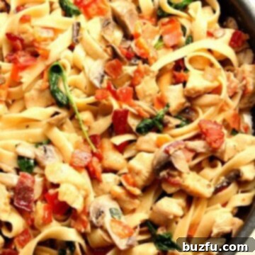 Creamy Mushroom Chicken Pasta with bacon in skillet.