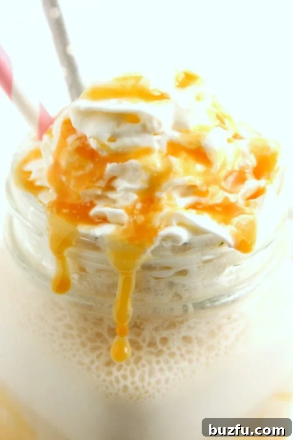 Easy Homemade Salted Caramel Frappuccino 2 A refreshing homemade salted caramel frappe in a clear mug, topped with whipped cream and caramel drizzle.