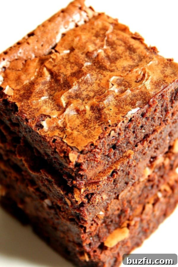 Close up shot of a stack of brownies on a clean white background, highlighting their rich color and inviting texture.