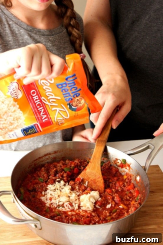 A child's hands adding ingredients to a skillet, symbolizing family cooking and involvement in the kitchen, with the Stuffed Pepper Rice Skillet in progress.