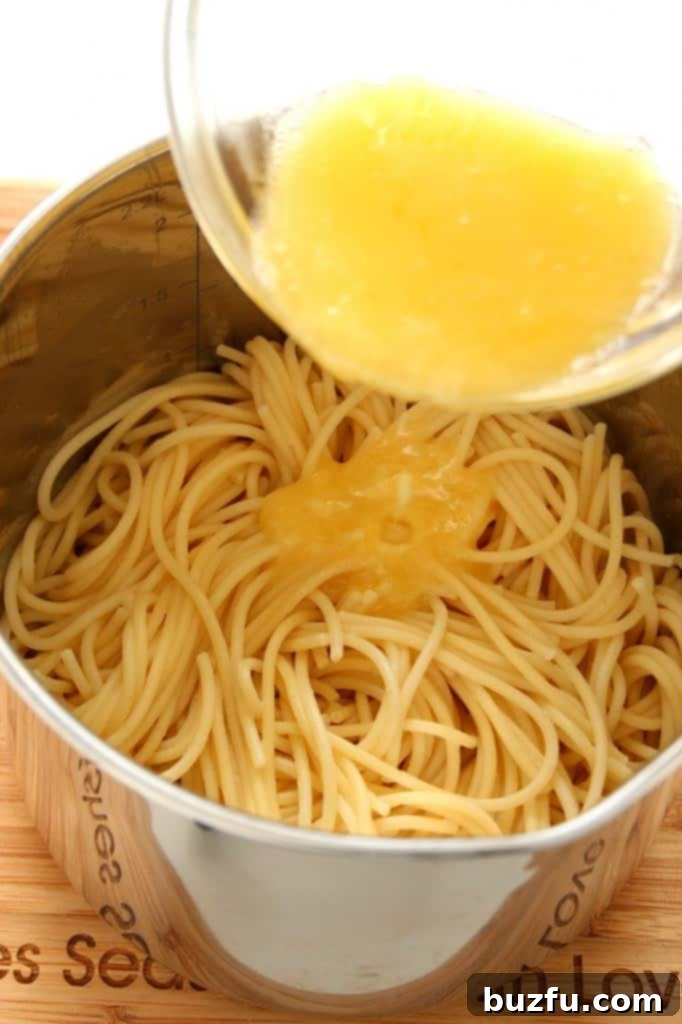 Perfectly Cooked Garlic Spaghetti for Meatballs Garlic spaghetti being gently tossed in a large pan after cooking.