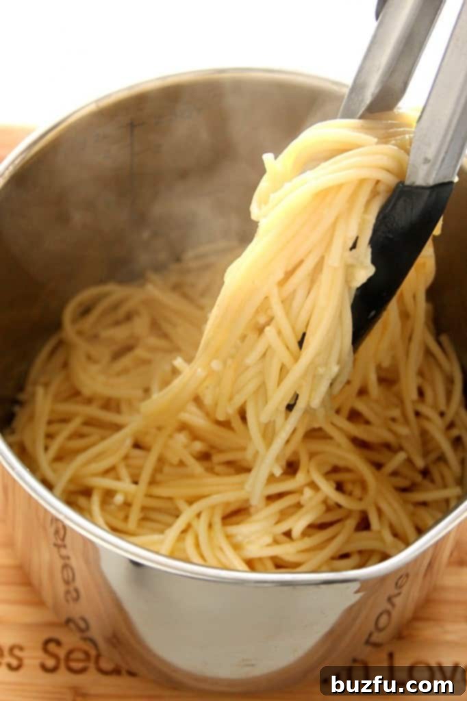 Homemade Turkey Meatballs Simmering in Sauce Closeup of a single turkey meatball simmering in homemade tomato sauce.