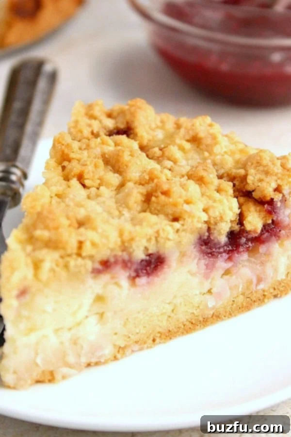 Raspberry Coconut Sour Cream Crumb Pie Recipe - sweet and creamy coconut filling with a tarty raspberry jam, all under a buttery crunchy crumb topping. This pie is easy and absolutely delicious! A delectable slice of Raspberry Coconut Sour Cream Crumb Pie on a pristine white plate, showcasing its golden crumb topping, creamy coconut filling, and streaks of ruby-red raspberry jam.