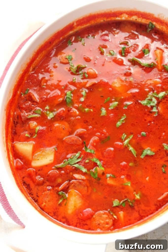 Italian Sausage soup simmering in a large soup pot.