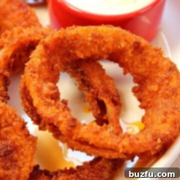 Zesty Buffalo Onion Rings 5 Onion rings with dipping sauce, close up