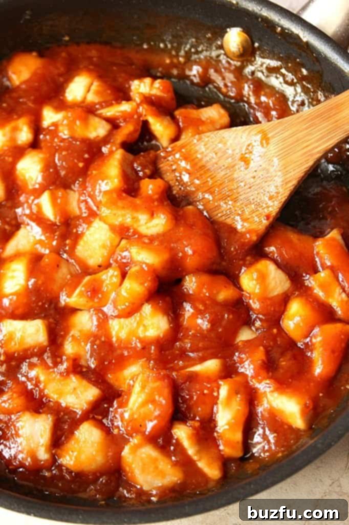 Effortless Honey Chipotle Chicken Rice Bowls 3 Close-up of golden-brown honey chipotle chicken pieces simmering in a rich, glossy sauce with vibrant Asian vegetables.