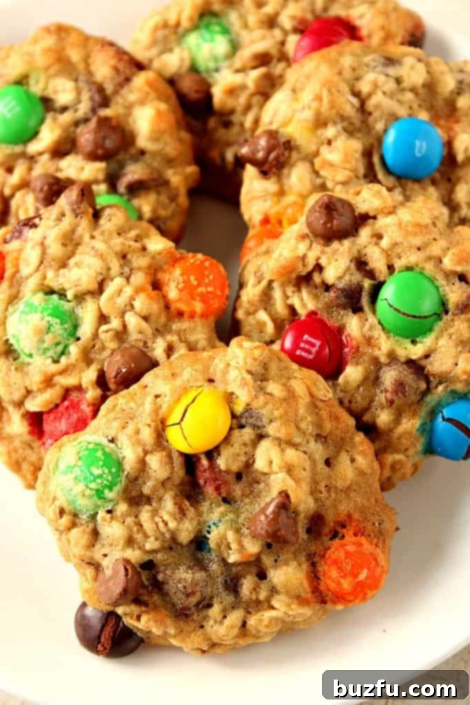 A close-up shot of chewy oatmeal cookies adorned with colorful M&M candies, arranged appealingly on a plate.