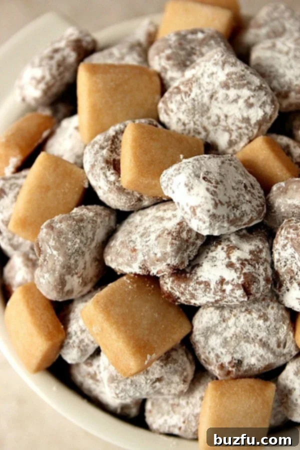 Muddy Buddies Shortbread Bites in a bowl, showcasing their powdered sugar coating and mini size.