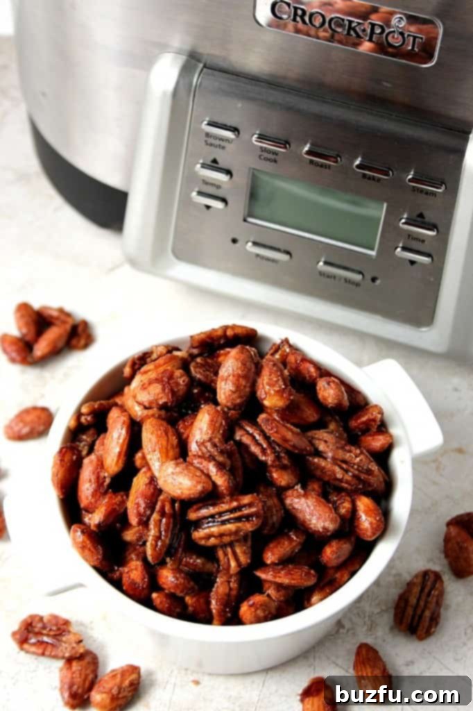 Close-up of freshly cooked Crock-Pot Candied Spiced Nuts cooling on parchment paper.
