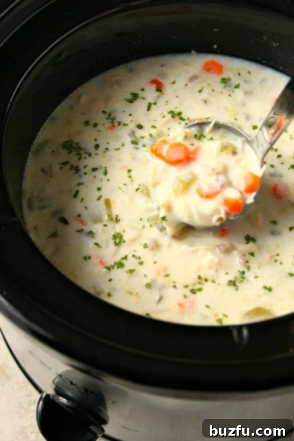 Slow Cooker Chicken Wild Rice Soup simmering in a round crockpot, ready to be thickened and served.