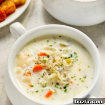 A bowl of creamy Slow Cooker Chicken Wild Rice Soup with a side of bread.