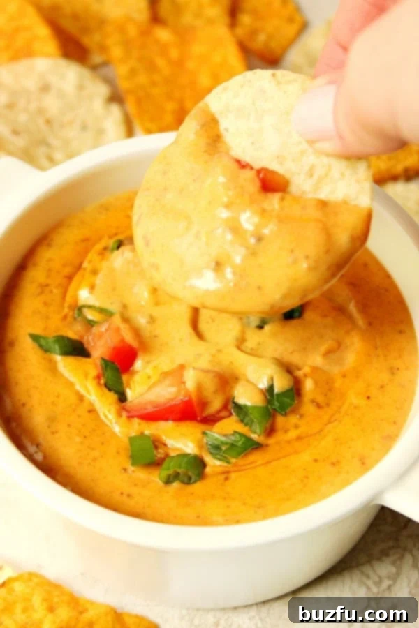 Dip in white bowl with dipped tortilla chip.