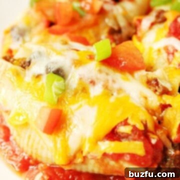 A close-up of a single Taco Stuffed Pasta Shell on a plate, showcasing the cheesy top and flavorful filling.