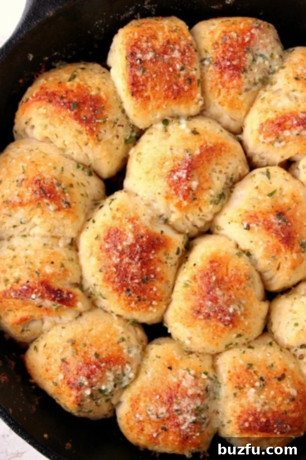 Garlic Parmesan Skillet Rolls in a cast iron skillet, golden brown and ready to be pulled apart.