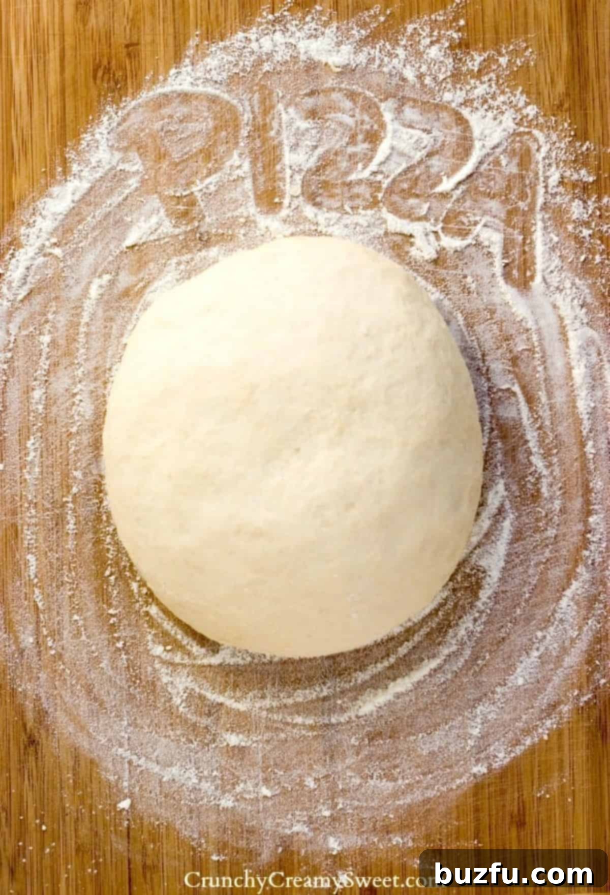 The Best Homemade Pizza Dough recipe - step-by-step guide Freshly made pizza dough resting on a rustic wooden board, ready to be shaped.