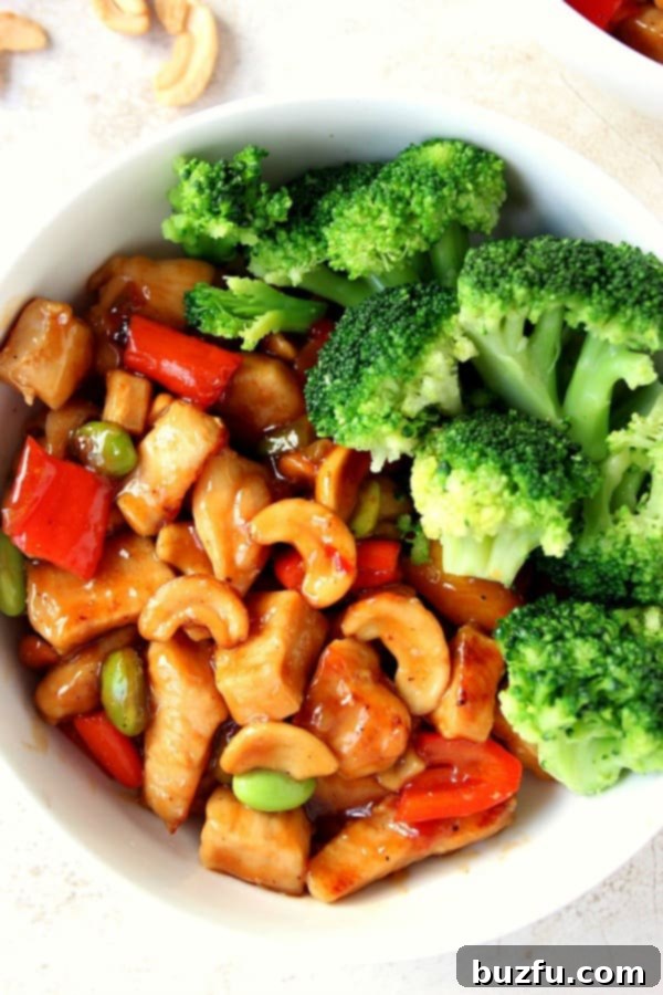 Chicken with cashews and broccoli in a white bowl, ready to be served.