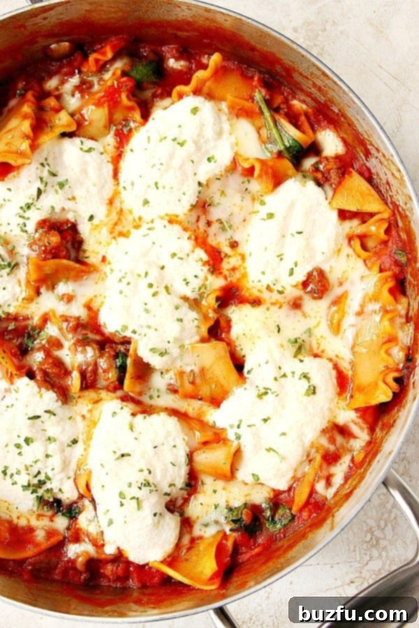 Overhead shot of lasagna in deep skillet, showcasing melted cheese and rich sauce.