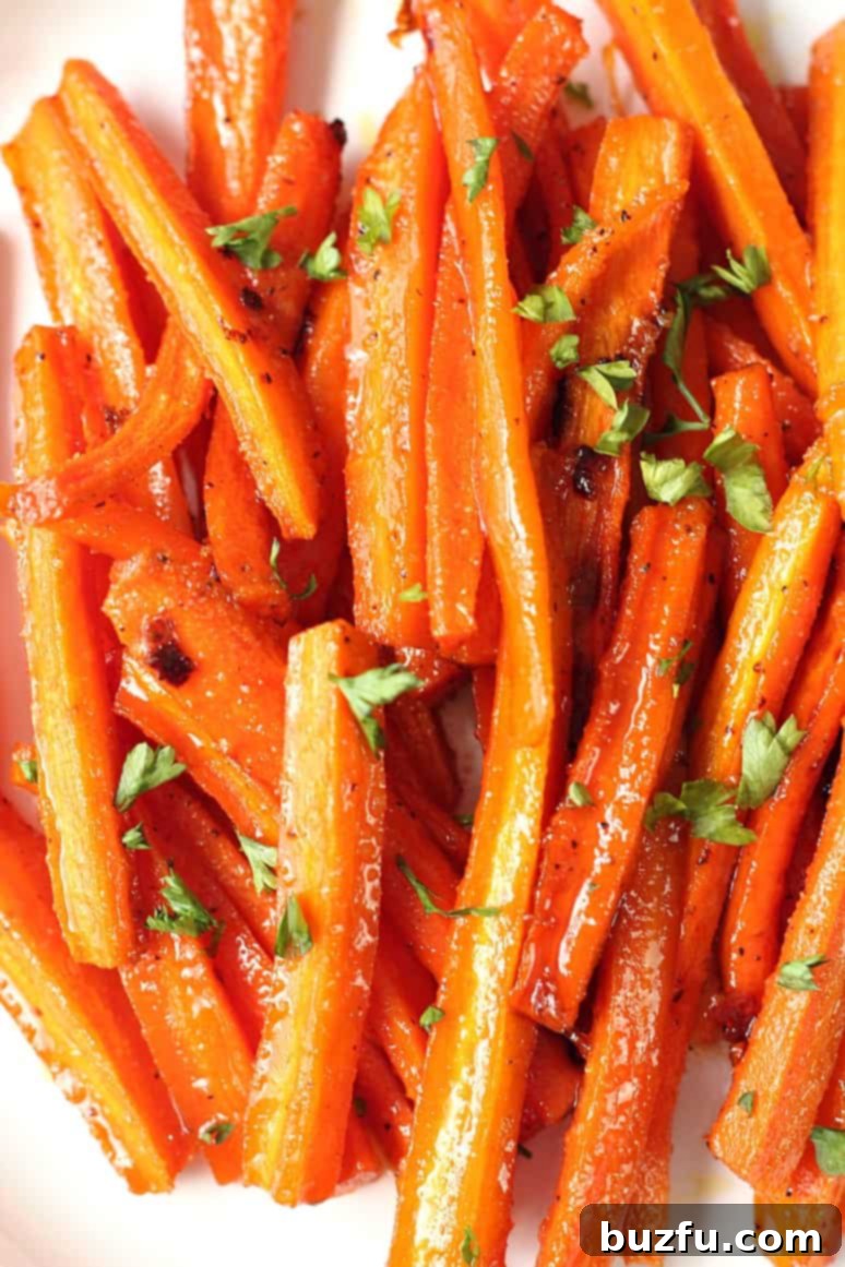 Brown Sugar Roasted Carrots - sweet and garlicky carrots roasted to perfection! The easiest and most delicious way to enjoy this vegetable! Close-up shot of perfectly roasted carrots, glistening with a brown sugar and garlic glaze.