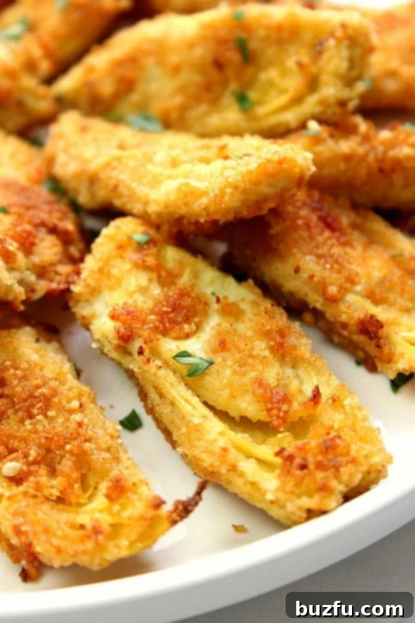 Perfectly golden and crispy Baked Artichoke Hearts served on a white plate, ready to be enjoyed as a delightful appetizer.