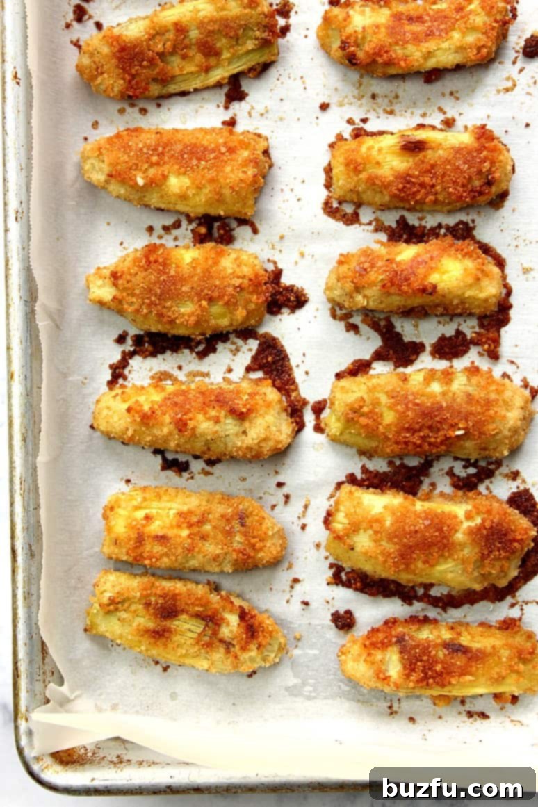 A close-up of a plate of Baked Artichoke Hearts Recipe, highlighting their golden brown and crispy texture, making them an ideal, easy-to-make appetizer.